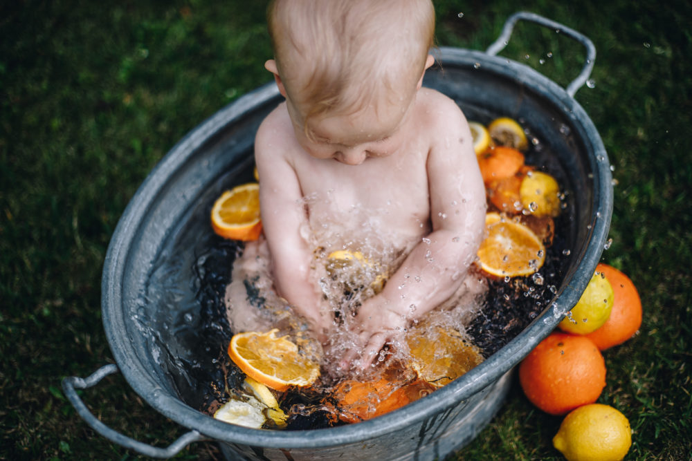 Kind badet in einer Zinkwanne
